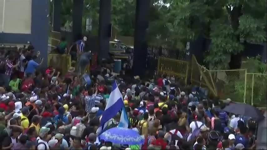 Migrants force through fence at Mexican border